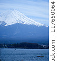 A small fishing boat floating under the majestic Mt. Fuji, Lake Kawaguchi, vertical composition 117650064