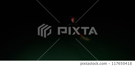 Authentic triathlete swimmer having a break during hard training on night 117650418