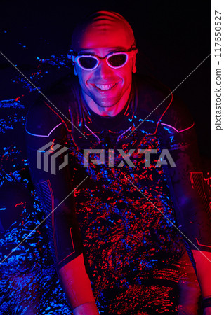authentic triathlete swimmer having a break during hard training on night neon gel light 117650527