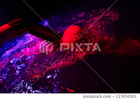 Authentic triathlete swimmer having a break during hard training on night neon gel light Authentic triathlete swimmer having a break during hard training on night neon gel light 117650561
