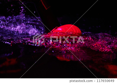 Authentic triathlete swimmer having a break during hard training on night neon gel light Authentic triathlete swimmer having a break during hard training on night neon gel light 117650649