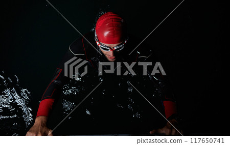 A triathlete finds serene rejuvenation in a lake, basking in the tranquility of the water after an intense training session A triathlete finds serene rejuvenation in a lake, basking in the tranquility of the water after an intense training session 117650741