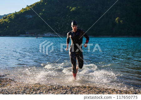 Triathlon athlete starting swimming training on lake Triathlon athlete starting swimming training on lake 117650775