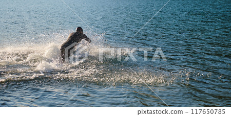 Triathlon athlete starting swimming training on lake 117650785