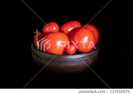 Ripe red tomatoes on a dark background Ripe red tomatoes on a dark background 117650870