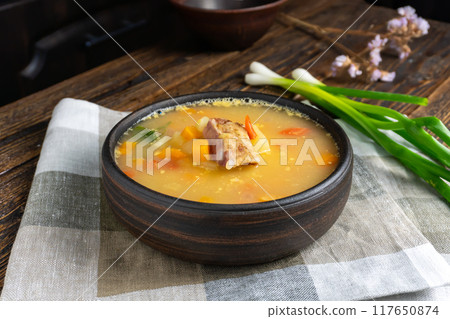 Pea Soup with Smoked Meats in Bowl on a Wooden Table 117650874