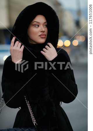 Muslim woman walking on an urban city street on a cold winter night wearing hijab Muslim woman walking on an urban city street on a cold winter night wearing hijab 117651006