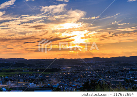 Evening view from a hill overlooking the town of Kizu in Kizugawa City, the southernmost part of Kyoto Prefecture. The sun sets over the Ikoma mountain range, painting the mountainside golden #2 117652694