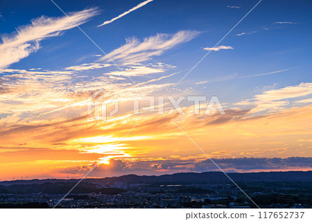 Evening view from a hill overlooking the town of Kizu in Kizugawa City, the southernmost part of Kyoto Prefecture. The sun sets over the Ikoma mountain range, painting the mountainside golden #37 117652737
