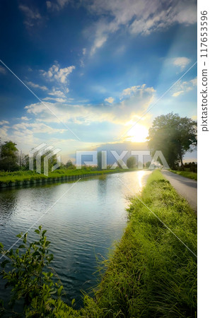 A Serene River Landscape at Sunrise Highlighted by Lush Greenery and Natural Beauty A Serene River Landscape at Sunrise Highlighted by Lush Greenery and Natural Beauty 117653596