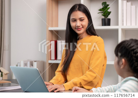 Mother smiles at daughter while working from home Mother smiles at daughter while working from home 117656714