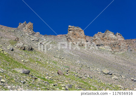 mountain landscape, rocky slope scree with towering cliffs dykes 117656916