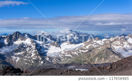 panoramic high mountainous landscape of Caucasus, peaks and glaciers among clouds panoramic high mountainous landscape of Caucasus, peaks and glaciers among clouds 117656985