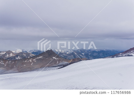 view of the high mountains above the clouds from the glacier on the slope of Mount Elbrus view of the high mountains above the clouds from the glacier on the slope of Mount Elbrus 117656986