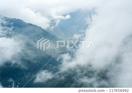 aerial view through the clouds to valley with mountain villages aerial view through the clouds to valley with mountain villages 117656992