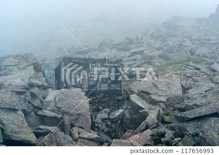ruins of a mountain hut among rocks in the highlands in thick fog ruins of a mountain hut among rocks in the highlands in thick fog 117656993