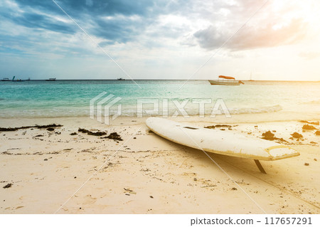 white surfing board on a sandy beach 117657291