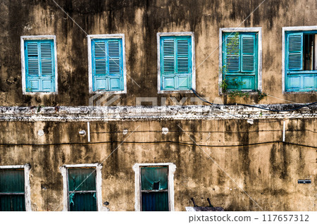 dirty neglected house with colorful windows 117657312