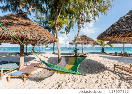 handmade chaise longues, straw umbrellas and hammock on a beach handmade chaise longues, straw umbrellas and hammock on a beach 117657322