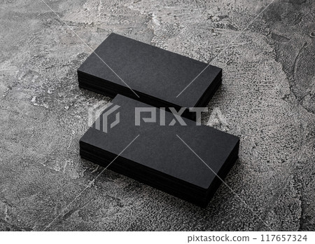 Stacks of black blank business cards on textured background 117657324