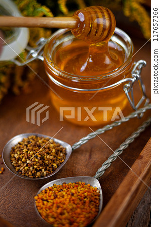 Bee honey and a wooden spoon. Sweet food. 117657366