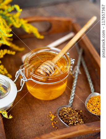 Bee honey and a wooden spoon. Sweet food. Bee honey and a wooden spoon. Sweet food. 117657367