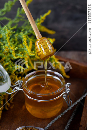 Bee honey and a wooden spoon. Sweet food. Bee honey and a wooden spoon. Sweet food. 117657368