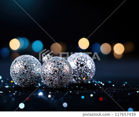 Three silver ornaments are sitting on a black background Three silver ornaments are sitting on a black background 117657439