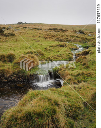 A stream runs down from Shelstone Tor high above it in the mist, Dartmoor UK 117657839