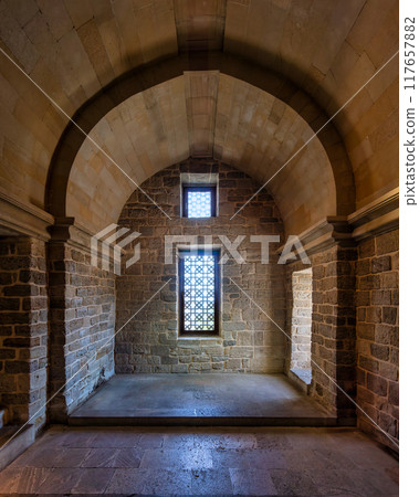 Historic stone chamber with arched ceiling and intricately patterned window in an ancient structure Historic stone chamber with arched ceiling and intricately patterned window in an ancient structure 117657882