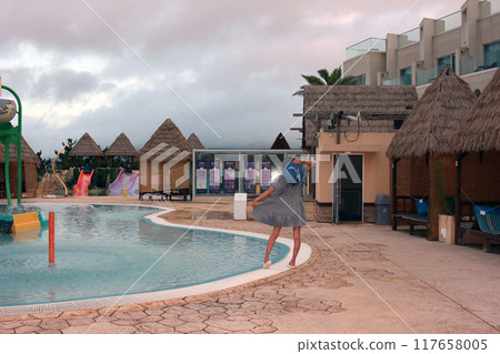Dolsan-eup, Yeosu-si, South Korea - July 26, 2024: Young woman watching sunrise at a resort with a swimming pool overlooking the sea in Yeosu 117658005