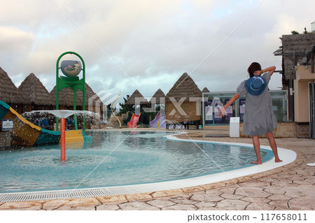 Dolsan-eup, Yeosu-si, South Korea - July 26, 2024: Young woman watching sunrise at a resort with a swimming pool overlooking the sea in Yeosu 117658011