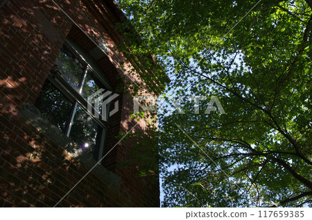 An elegant brick building stands on an old road. It was a decommissioned power plant. On a summer day, it quietly blended into the rural scenery. An elegant brick building stands on an old road. It was a decommissioned power plant. On a summer day, it quietly blended into the rural scenery. 117659385