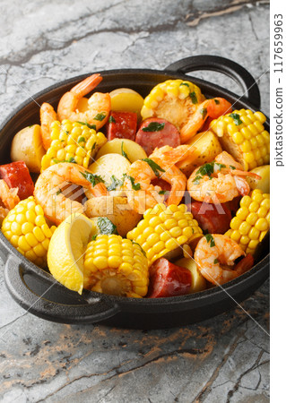 Classic shrimp boil that is a mixture of corn on the cob pieces, shrimp, smoked sausage and baby potatoes closeup. Vertical Classic shrimp boil that is a mixture of corn on the cob pieces, shrimp, smoked sausage and baby potatoes closeup. Vertical 117659963