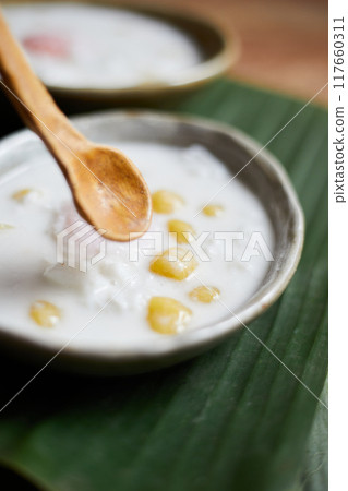 Thai glutinous rice balls with coconut milk on wood Thai glutinous rice balls with coconut milk on wood 117660311