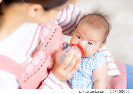 Mom holding baby, giving milk 117660691