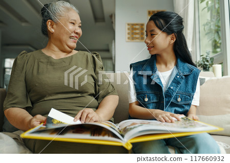 Grandma Showing Photo Album To Her Granddaughter 117660932