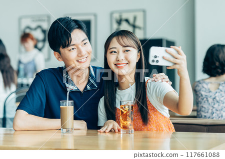 Young men and women relaxing in a cafe Young men and women relaxing in a cafe 117661088