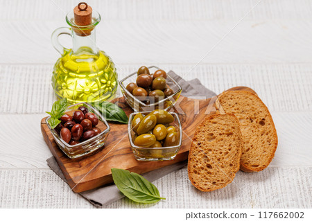 An assortment of various olives presented in a bowl, showcasing different colors, textures, and flavors An assortment of various olives presented in a bowl, showcasing different colors, textures, and flavors 117662002