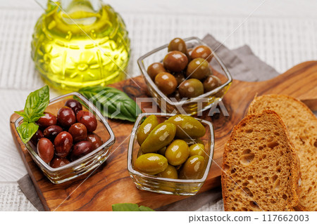 An assortment of various olives presented in a bowl, showcasing different colors, textures, and flavors 117662003
