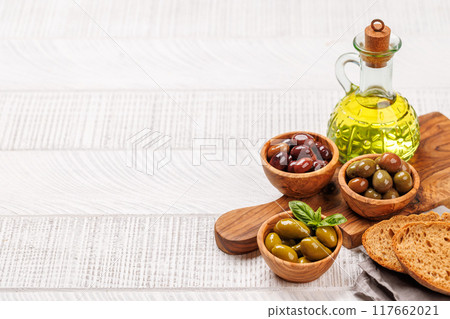 An assortment of various olives presented in a bowl, showcasing different colors, textures, and flavors An assortment of various olives presented in a bowl, showcasing different colors, textures, and flavors 117662021