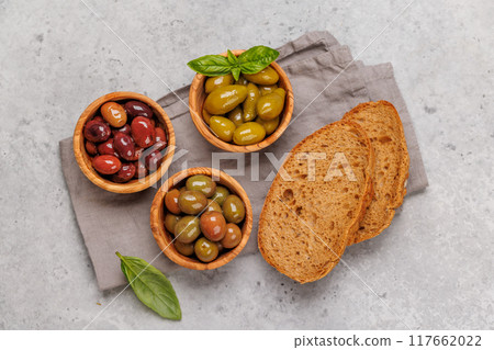 An assortment of various olives presented in a bowl, showcasing different colors, textures, and flavors An assortment of various olives presented in a bowl, showcasing different colors, textures, and flavors 117662022
