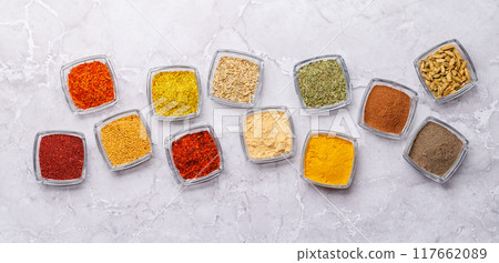 A vibrant assortment of various spices and herbs displayed together 117662089