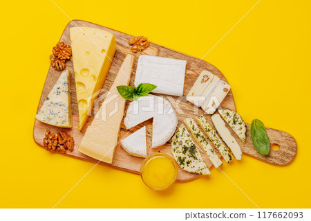 An assortment of various cheeses arranged on a board, highlighting different textures 117662093