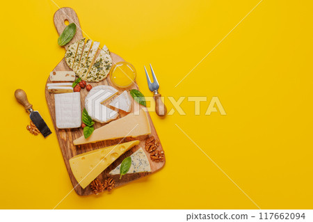 An assortment of various cheeses arranged on a board, highlighting different textures 117662094