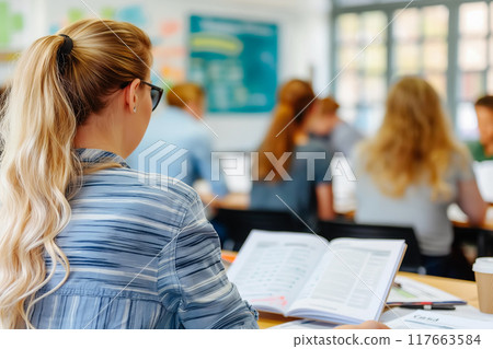 Group of multiethnic people, students sitting in well-lit university auditorium, listening to lecturer 117663584