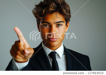 Businessman pointing upwards with confident little smile. focus on finger Businessman pointing upwards with confident little smile. focus on finger 117663610