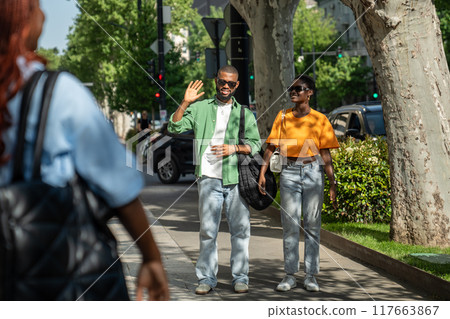Happy black man waving hand to friend, greeting. Guy on date with girl, students meet classmate. 117663867