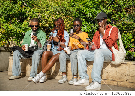 Focused on smartphones black students friends do not pay attention to each other on walk together. Focused on smartphones black students friends do not pay attention to each other on walk together. 117663883
