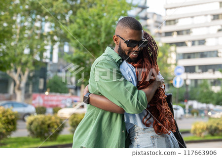 Happy African American couple, students hugging each other goodbye, cuddling as greeting outside 117663906